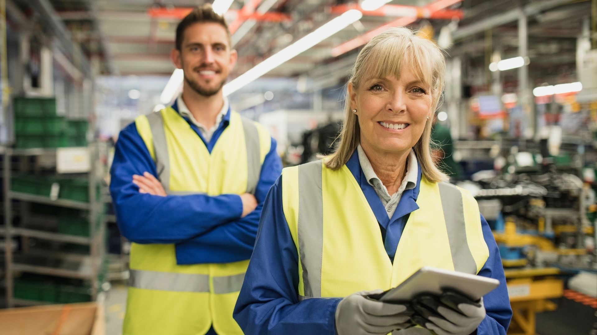 two frontline workers in safety vests smiling
