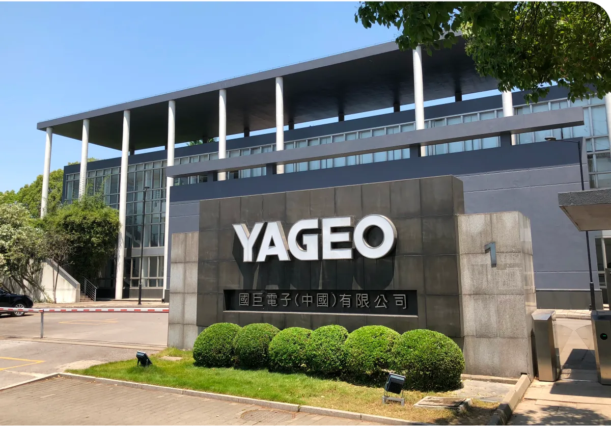 Building exterior with "YAGEO" signage, featuring modern architecture, large windows, and a manicured garden in front.
