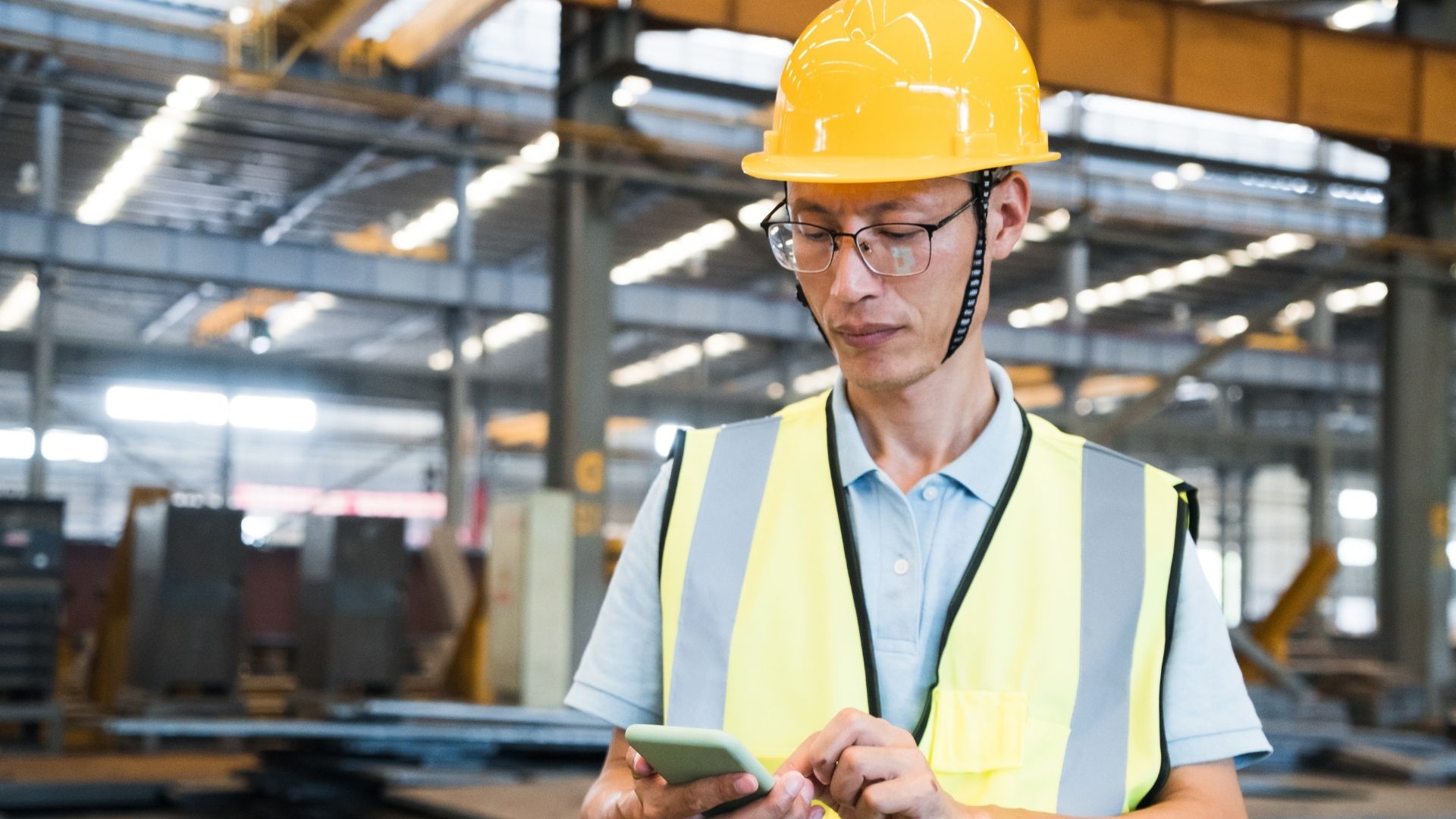worker in hard hat and vest on phone