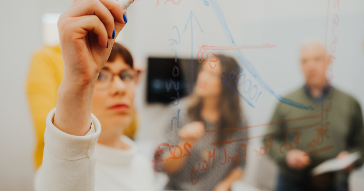woman writing on whiteboard in office