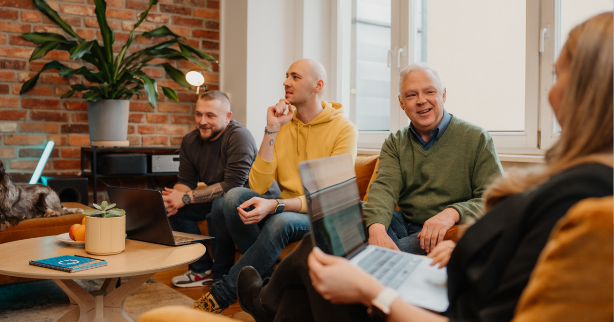 coworkers speaking around a table with open laptops