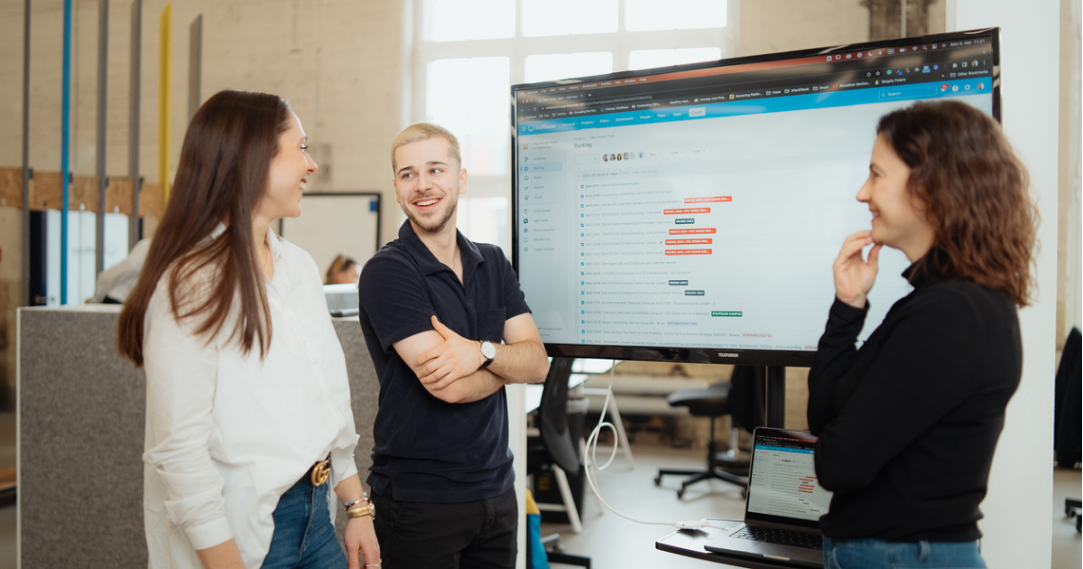 three people speak around a presentation screen