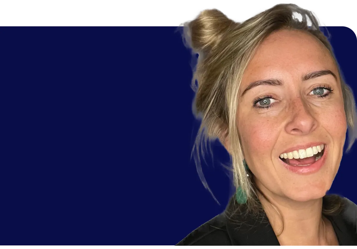 Smiling woman with blonde hair in a bun, wearing a black top, against a dark blue background.