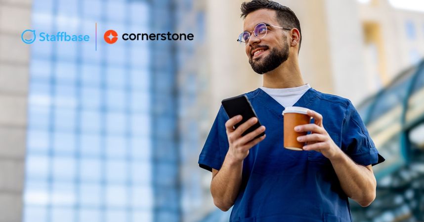 man in scrubs smiles with coffee