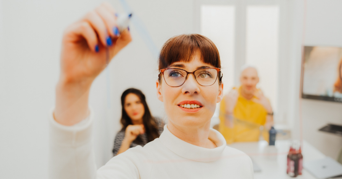 woman writing on board brainstorming