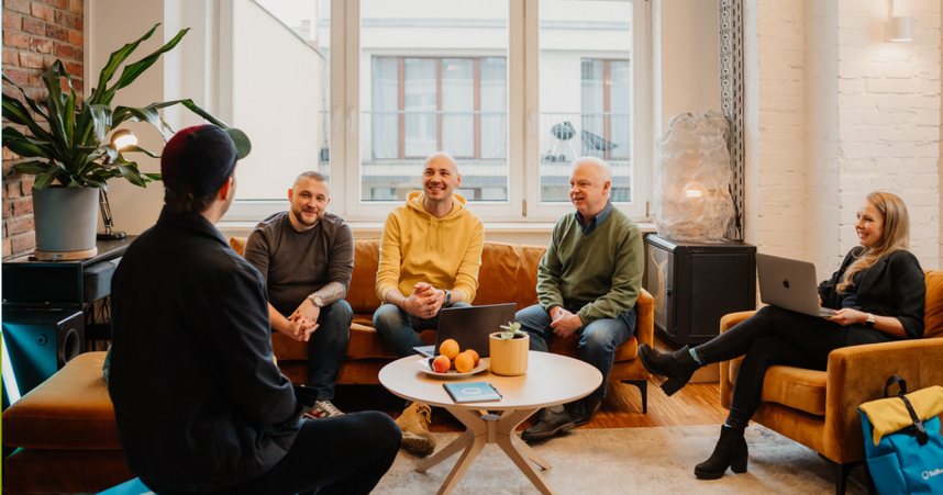 coworkers sitting in a circle talking and smiling