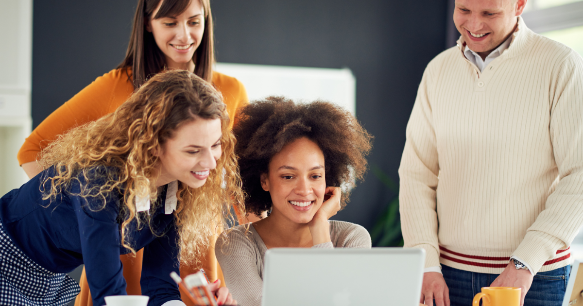 people at work smiling at a laptop