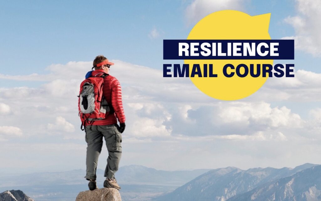 A person in hiking attire stands on top of a mountain and looks into the distance. The words