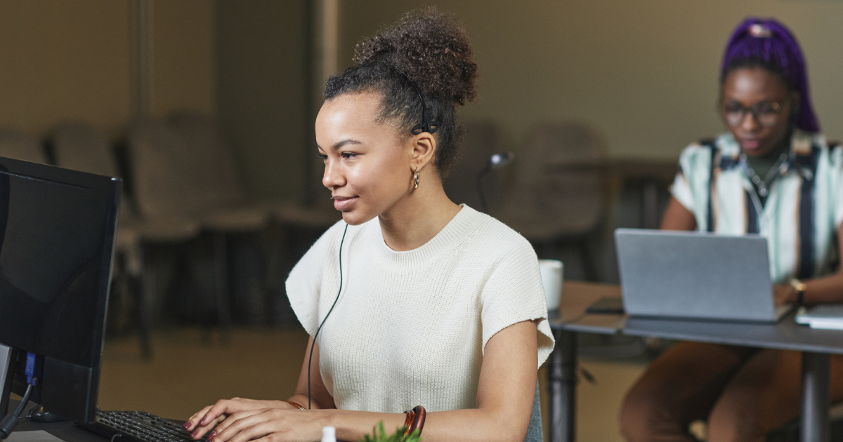woman on computer with headphone and soft smile