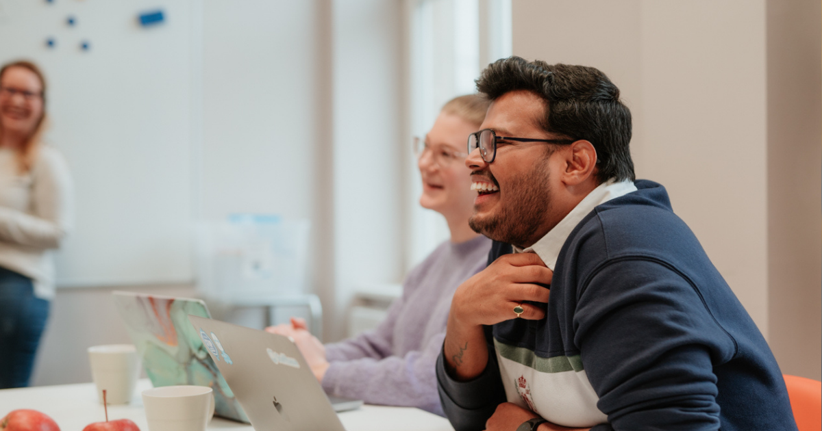 workers smiling around a laptop