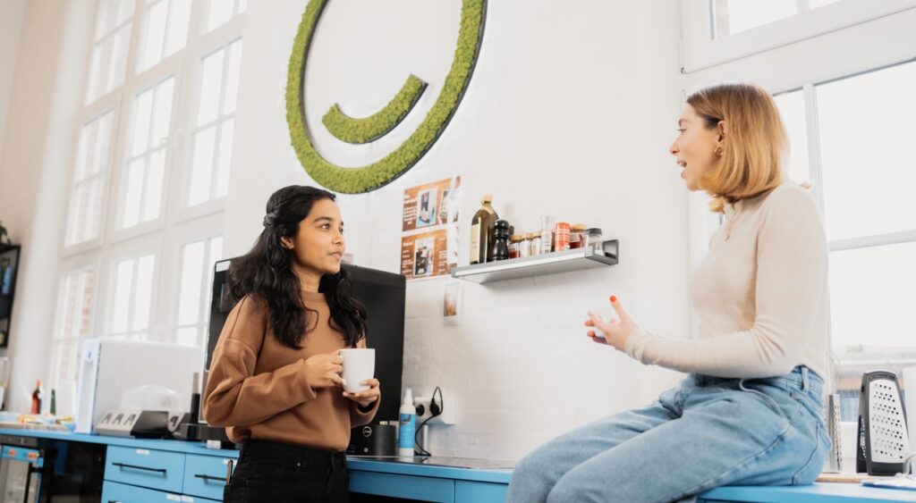 Menschen treffen sich an der Kaffeemaschine im Büro