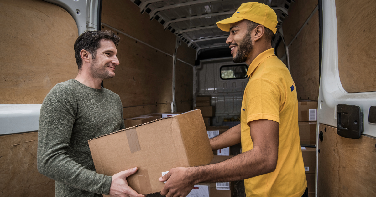man in delivery outfit gives box to customer