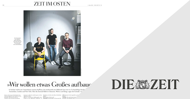 Three men sitting and standing in a minimalist room with a white brick wall, featured in a magazine layout with "ZEIT IM OSTEN" text.