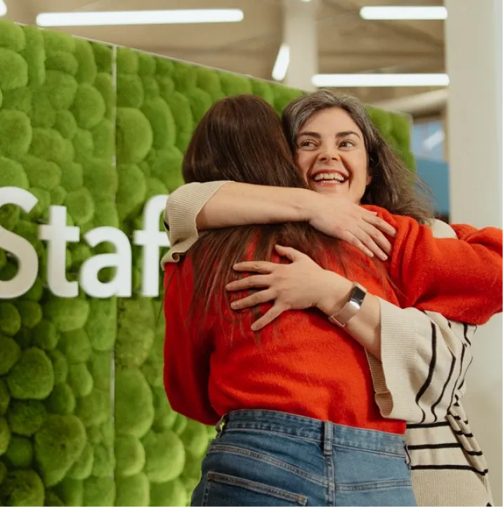 Smiling woman hugging another person