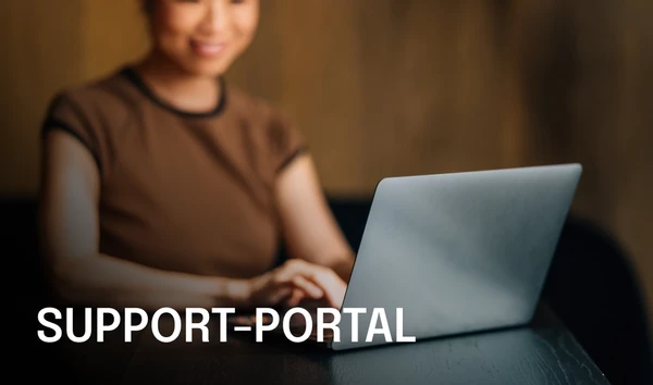 Woman using a laptop with the text "Support Portal" on the left. The background is softly blurred, emphasizing the focus on the laptop.