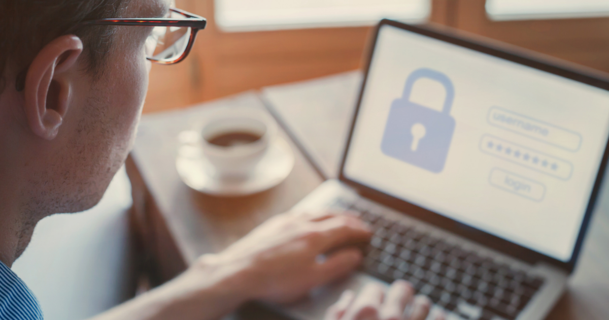 man looks at laptop that has a locked image and login page