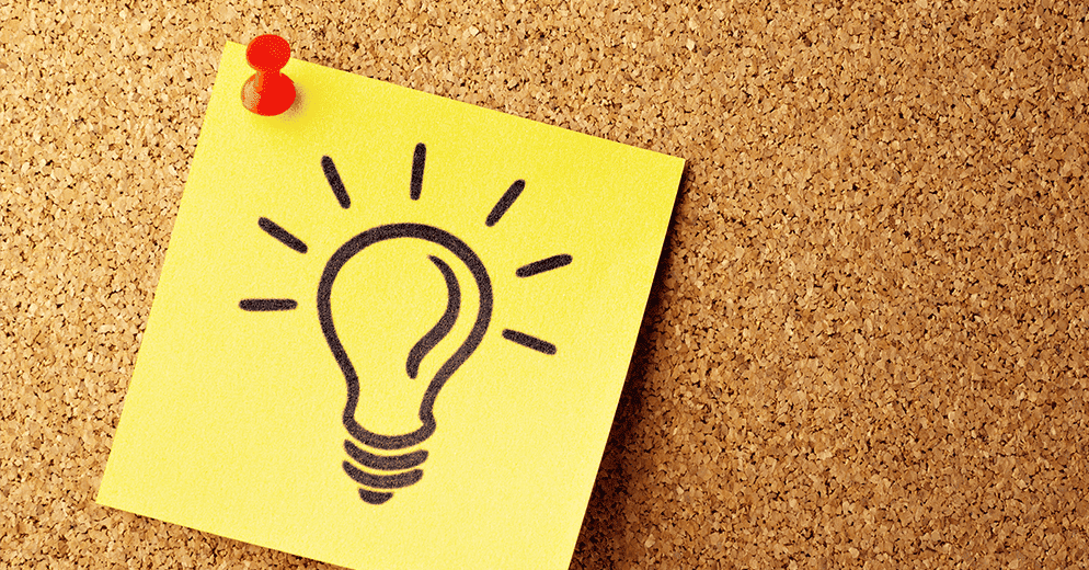 Ideenfindung: ein Post-it mit einer gezeichneten Glühbirne an einer Pinnwand befestigt.