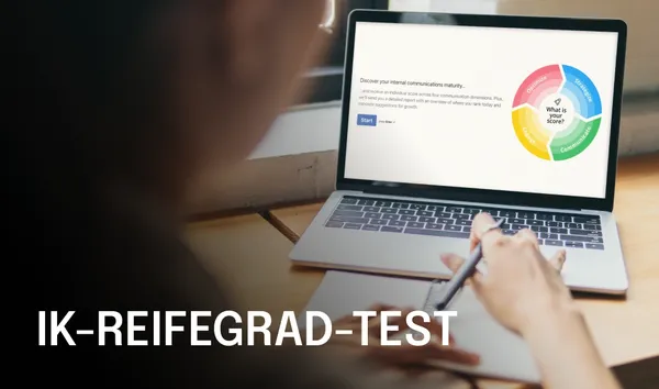 Person writing on paper with a laptop displaying a "Comms Maturity Assessment" diagram, featuring a colorful circular chart.