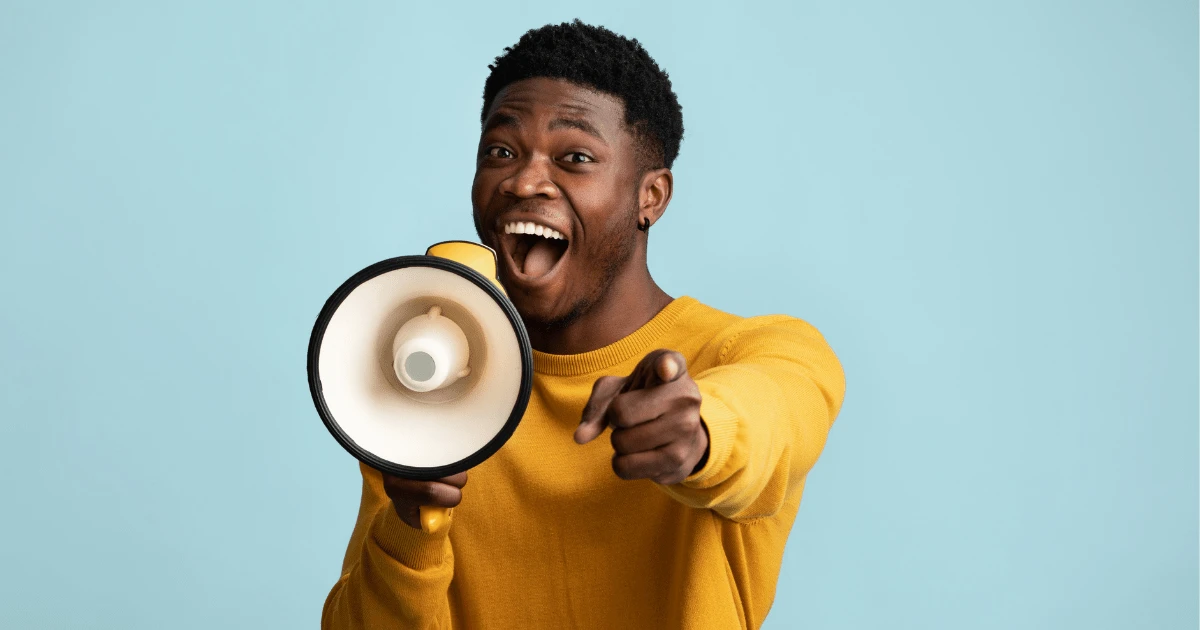 man with microphone pointing ahead in apparent excitement