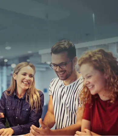 rei Mitarbeitende arbeiten entspannt mit Laptops in einem modernen Bürobereich mit großen, türkisfarbenen Sitzsäcken.
