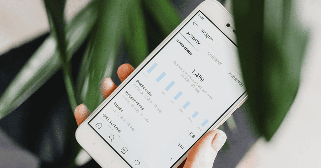 Person checkt Insights auf dem Smartphone für die Analyse und Erfolgskontrolle der Social-Media-Kanäle.