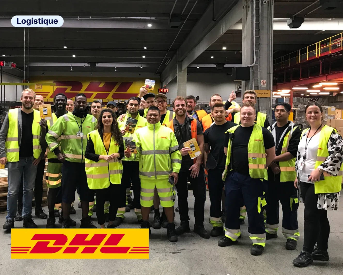 Une vingtaine d'employés DHL en gilets jaunes fluorescents posent ensemble dans un entrepôt logistique, illustrant le cas client Staffbase dans le secteur de la logistique