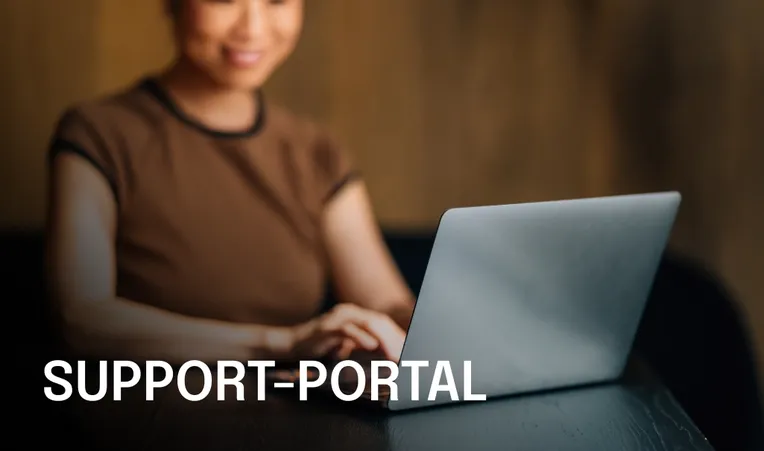 Woman using a laptop with the text "Support Portal" on the left. The background is softly blurred, emphasizing the focus on the laptop.