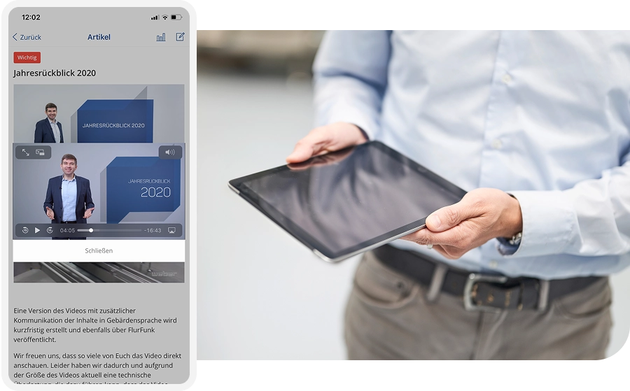 Person in a blue shirt holding a tablet, with a screen showing a video titled "Jahresrückblick 2020" featuring a man in a suit.