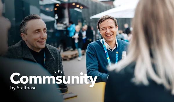 People smiling and talking at an outdoor event with food trucks in the background. Text overlay reads "Commsunity by Staffbase."