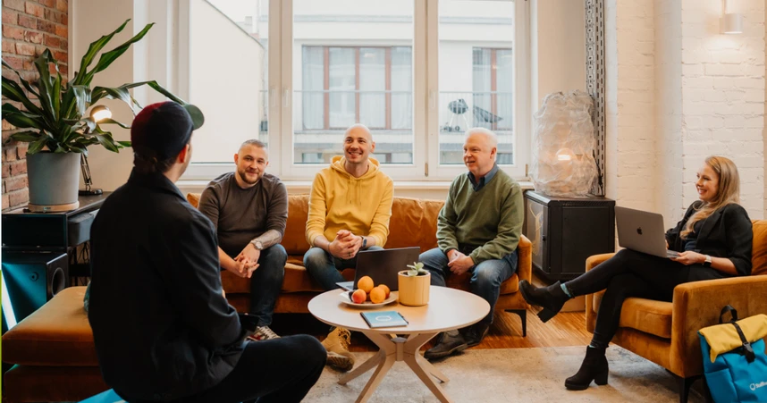 coworkers sitting in a circle talking and smiling