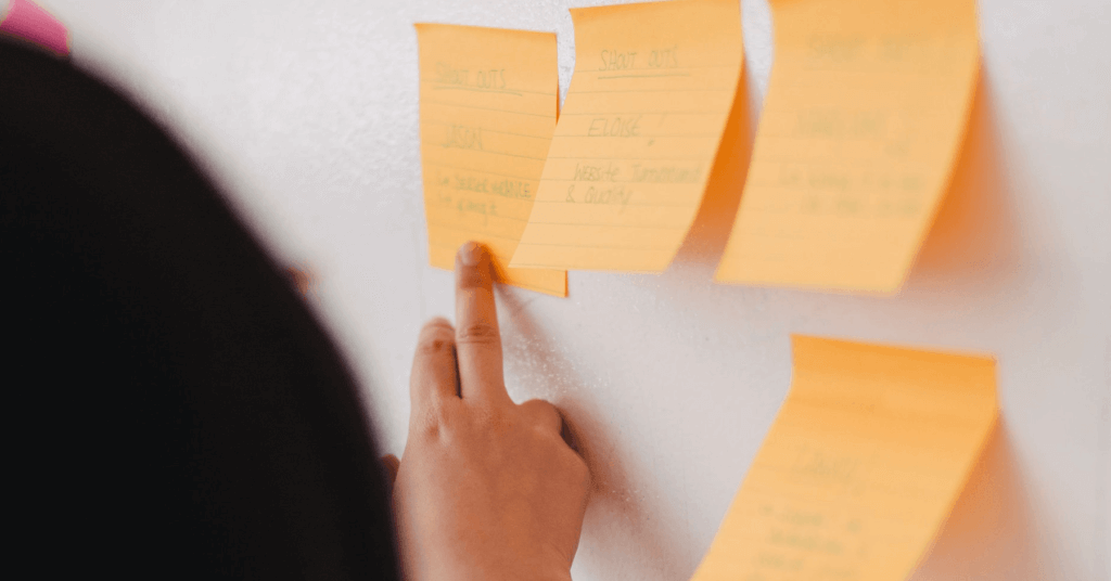 Eine Person beschriftet Post-its bei der Social-Media-Redaktionsplanung.