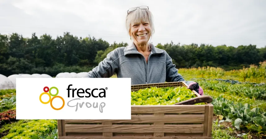 Smiling person in a garden holding a crate of lettuce. Fresca Group logo overlaid in the foreground.