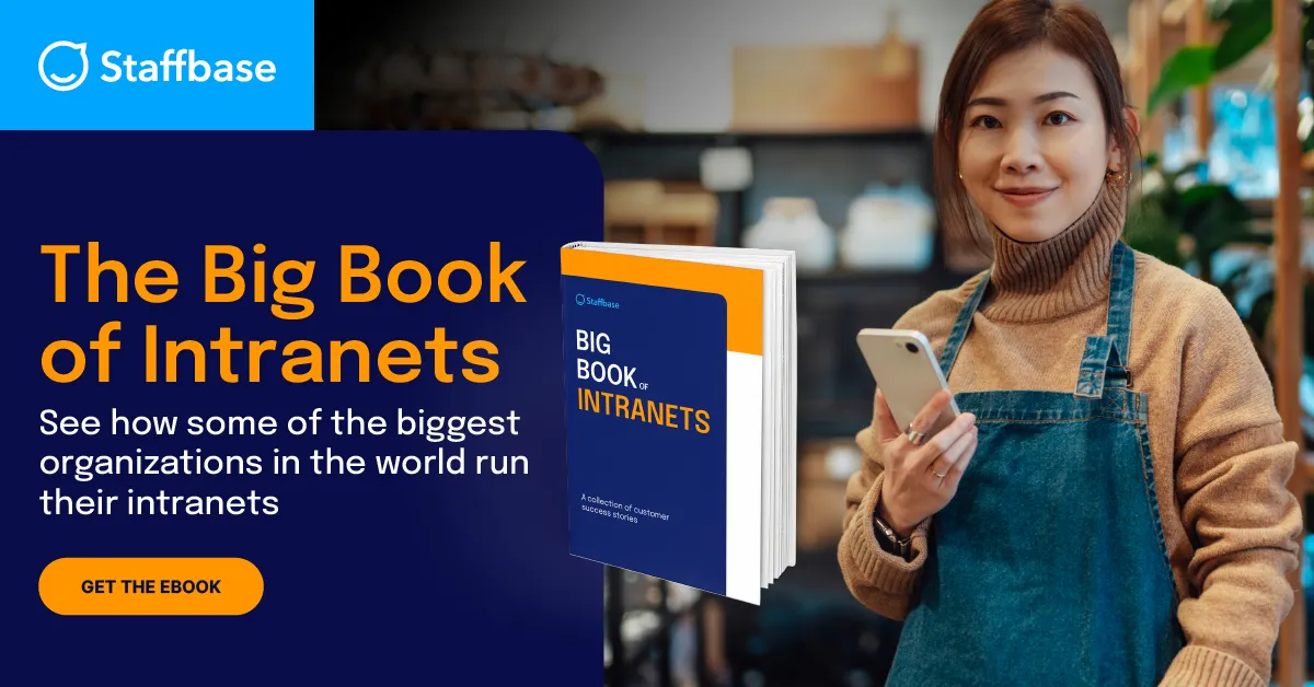 "Promotional graphic from Staffbase featuring a young woman in a beige turtleneck and denim apron holding a smartphone, smiling at the camera. On the left side, bold text reads: 'The Big Book of Intranets – See how some of the biggest organizations in the world run their intranets.' A 3D rendering of the book 'Big Book of Intranets' is displayed next to the text, along with an orange button labeled 'Get the Ebook.'