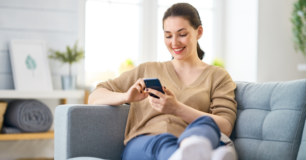 woman smiling while using phone