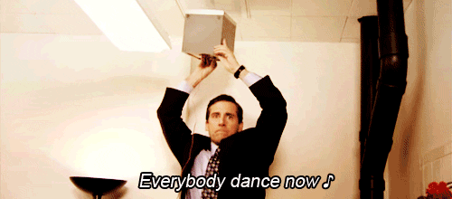 Michael Scott from the office dances on a chair and holds a speaker up to the ceiling while singing