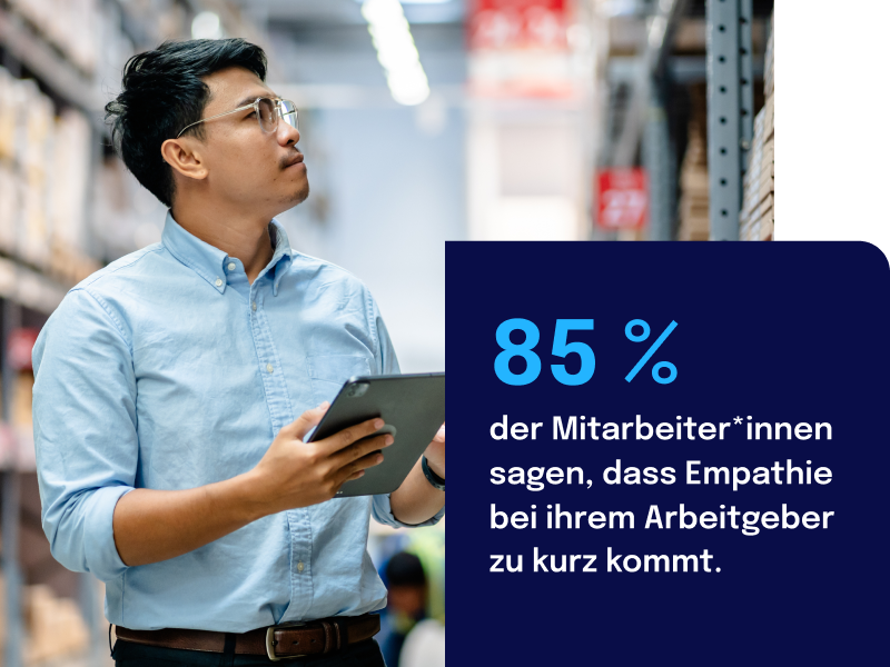 Man in a warehouse holding a tablet, with text stating 85% of employees feel empathy is undervalued by their employer.