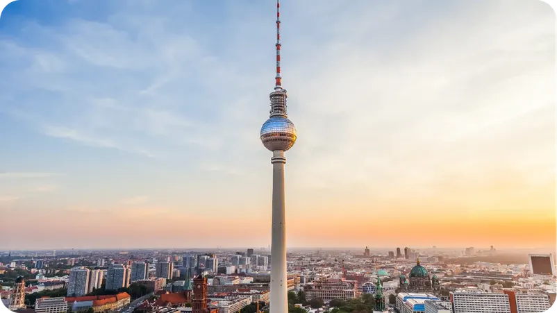 The Berlin TV Tower (Fernsehturm) rising above the city skyline at golden sunset. Title: Berlin TV Tower at Sunset