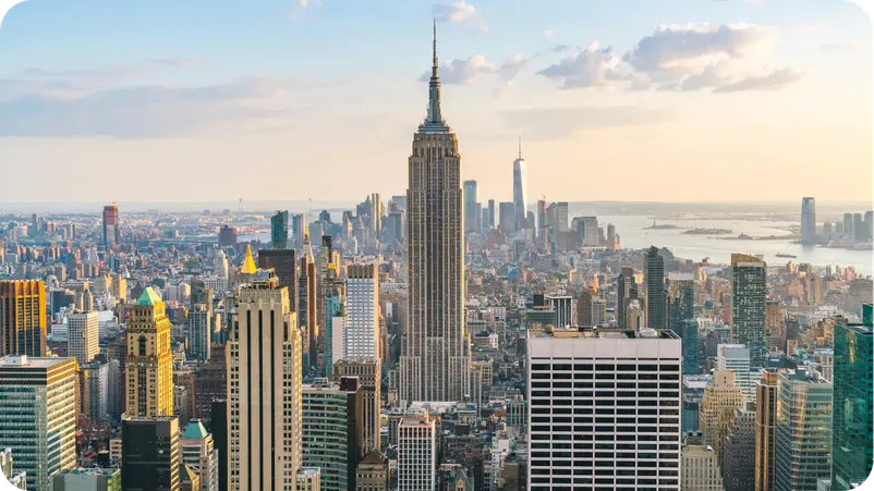 Aerial view of New York City skyline with the Empire State Building and New York Harbor in the background.