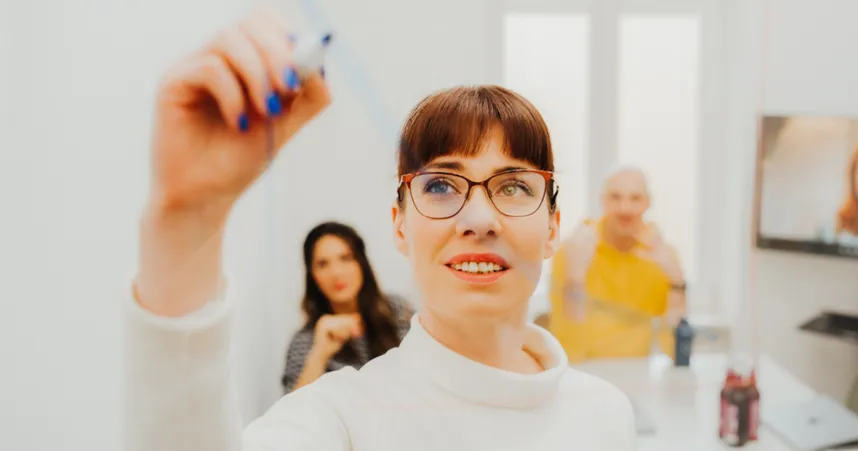 woman writing on board brainstorming