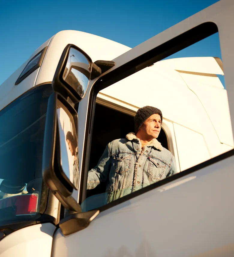 Truck driver exiting vehicle while sun is shining brightly
