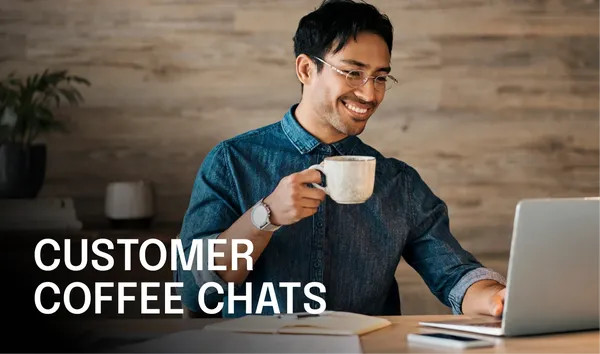 Smiling person in glasses holds a coffee mug while using a laptop. Text reads "Customer Coffee Chats" on the image.