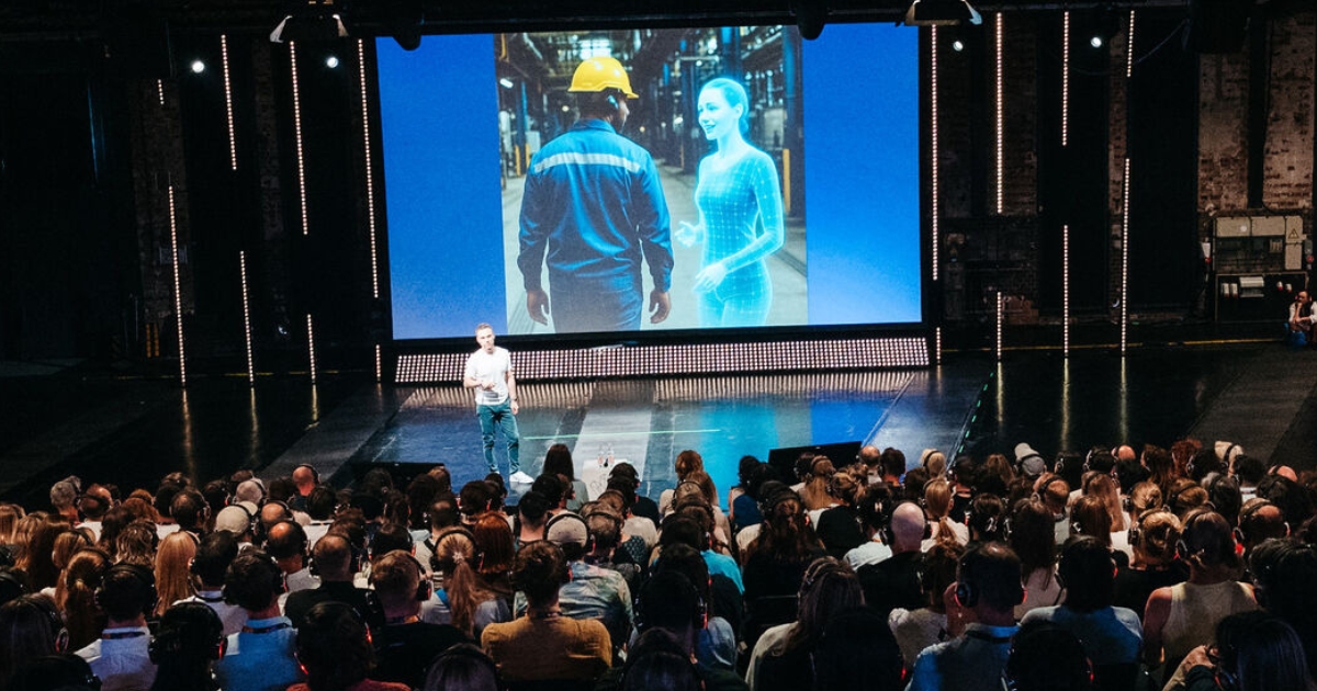 Frank Wolf speaking about AI at VOICES 2025 with presentation in background